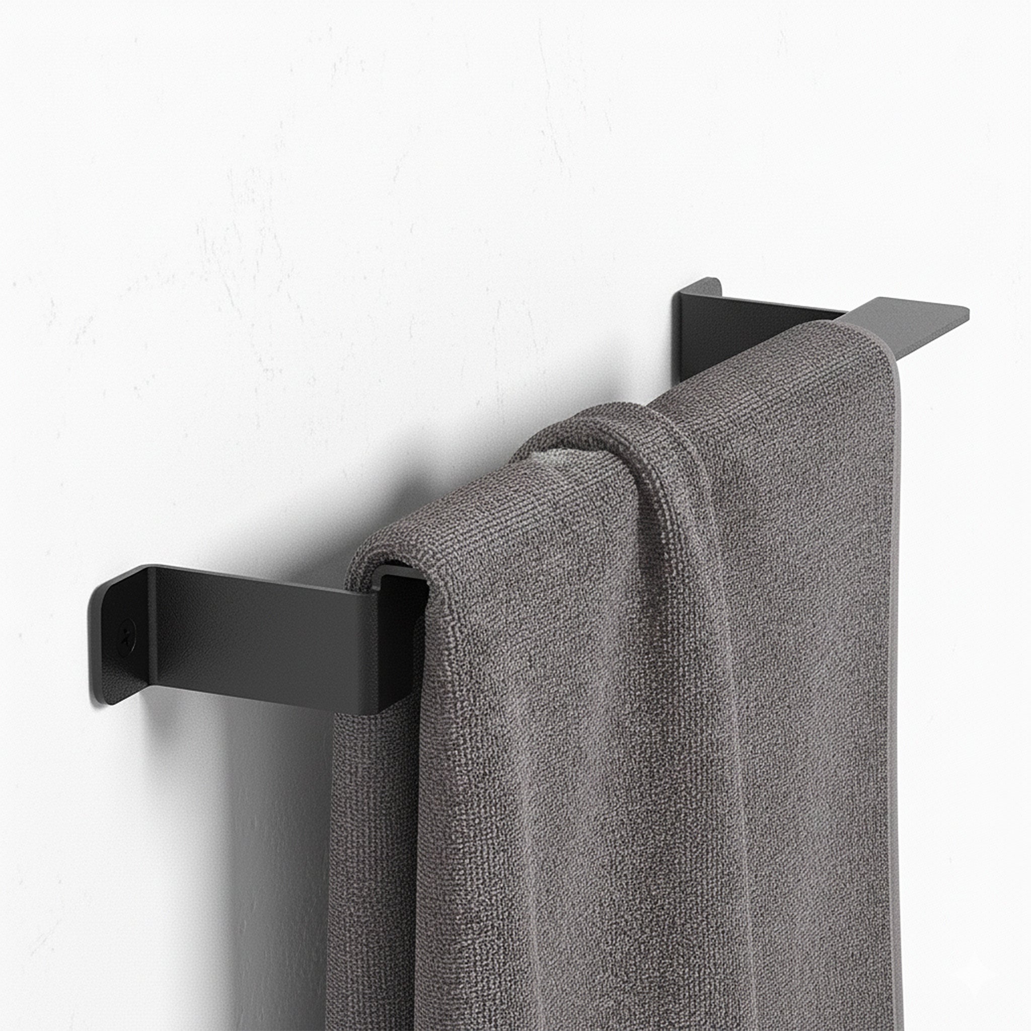 Minimalist black stainless steel towel rail mounted on wall with gray towel hanging